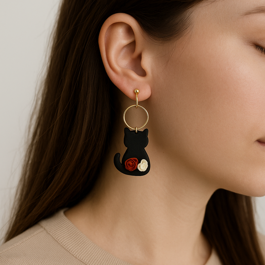 Close-up of a black cat earring with a red and white rose details