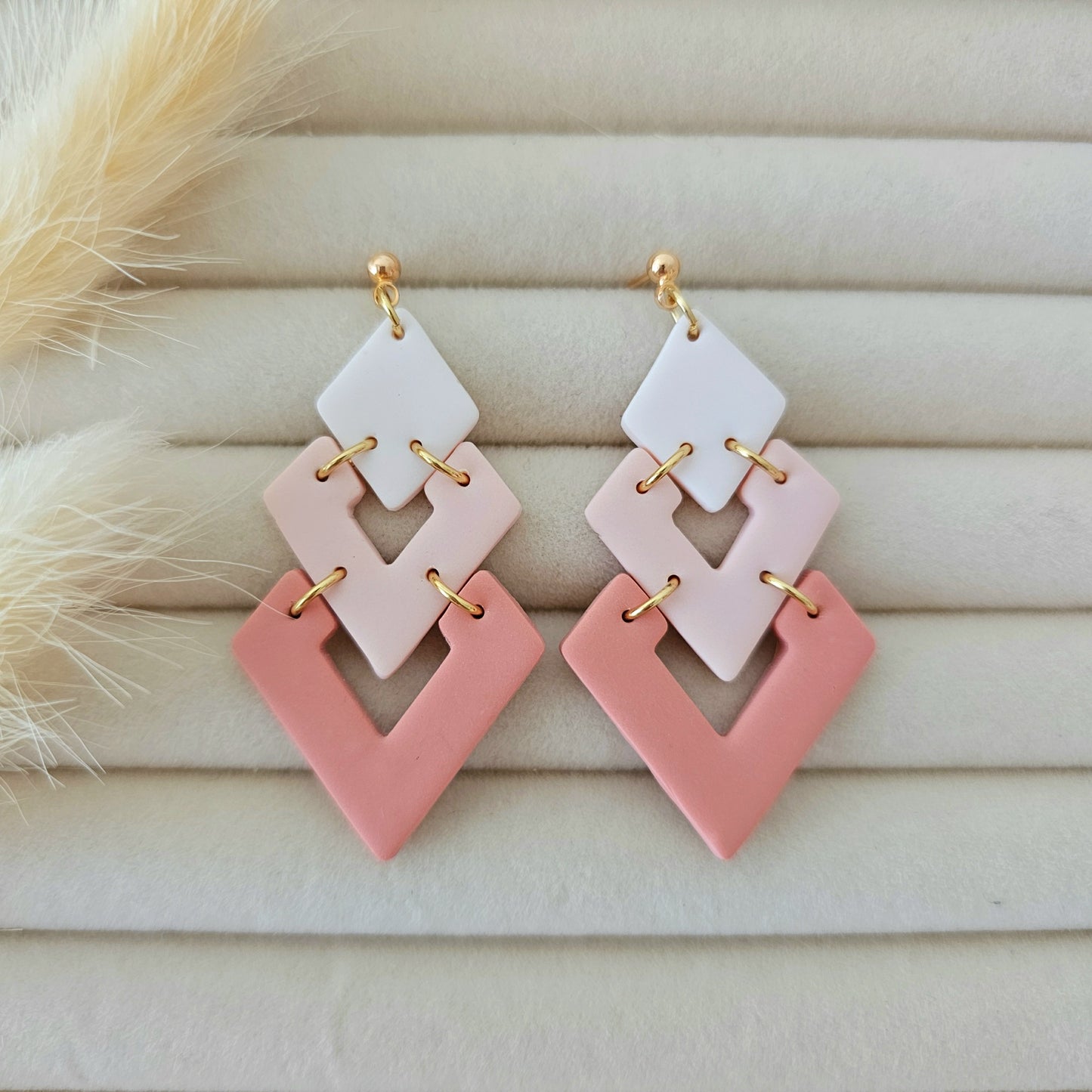 Pair of geometric earrings with pink and white design